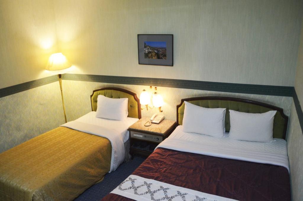 una camera d'albergo con due letti e un telefono di Guang Haw Hotel a Tainan