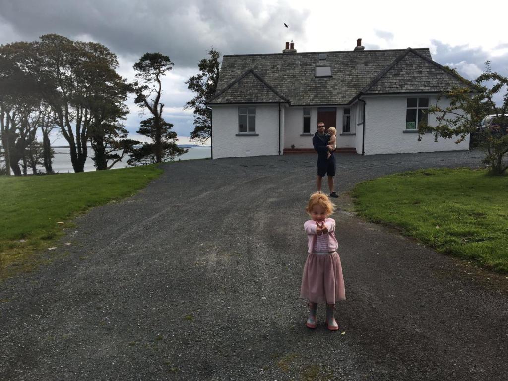 una niña parada frente a una casa en The Hide en Newtownards