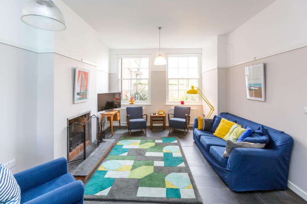 uma sala de estar com um sofá azul e uma lareira em Watermans em Aldeburgh