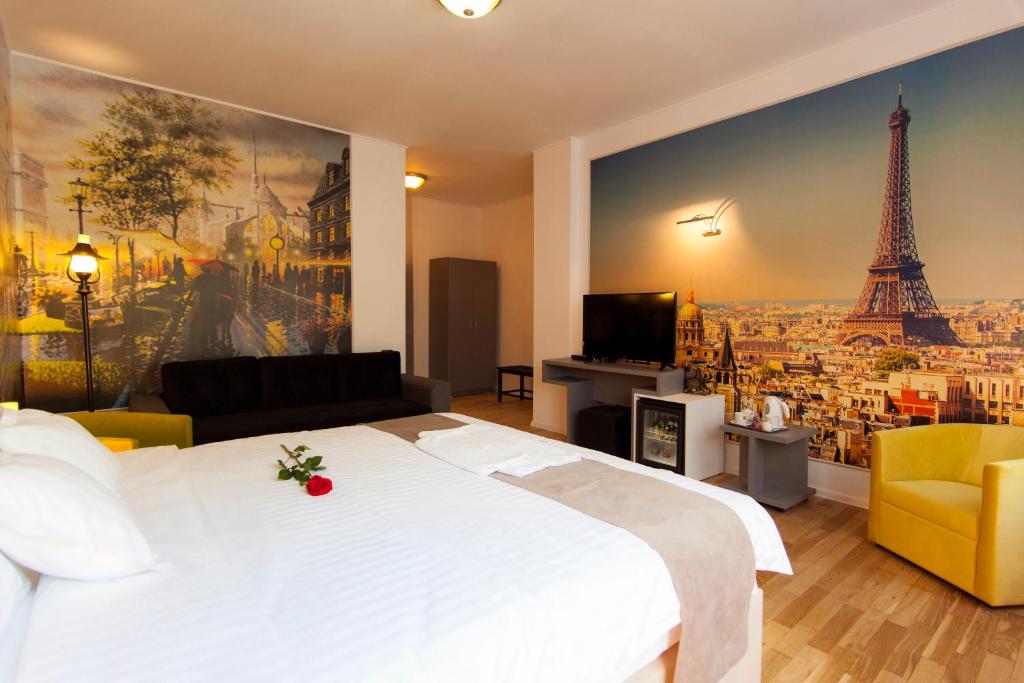 a bedroom with a white bed and a painting of the eiffel tower at Ambra Boutique Hotel & Bistro in Constanţa
