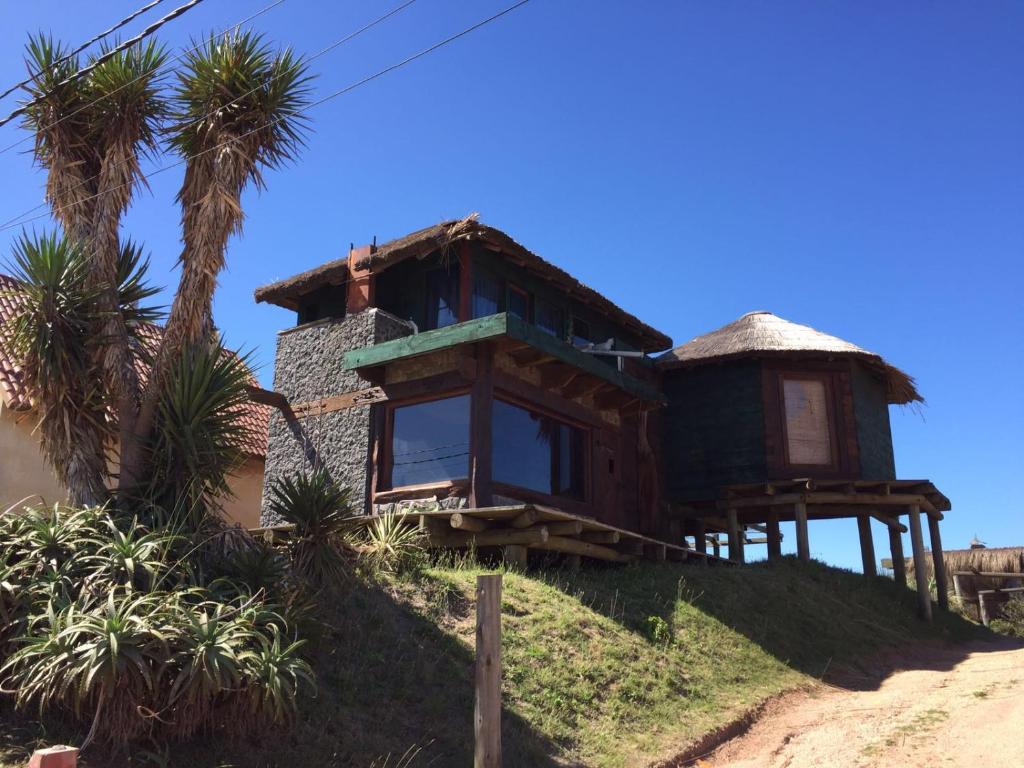 una casa en la cima de una colina con palmeras en Casa del Diavolo, en Punta del Diablo