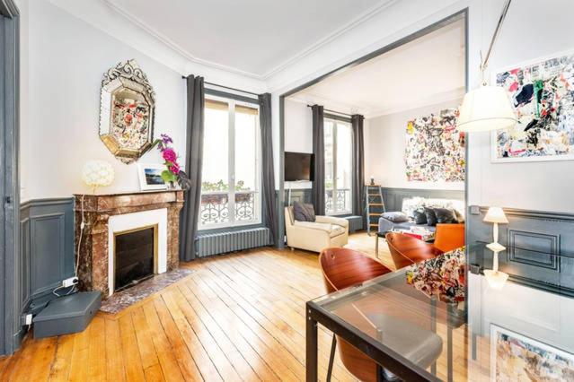 a living room with a fireplace and a table at Large & Bright Apartment, Central Paris, Montmartre-Opéra, Picturesque Rue des Martyrs in Paris