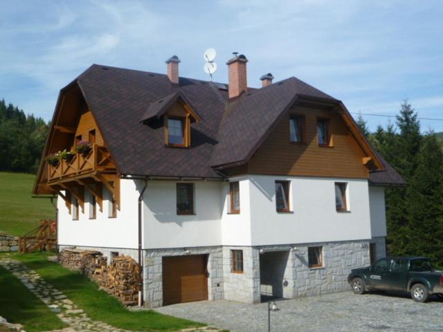 Casa blanca grande con techo marrón en Apartmany Kolb Ramzová, en Ostružná