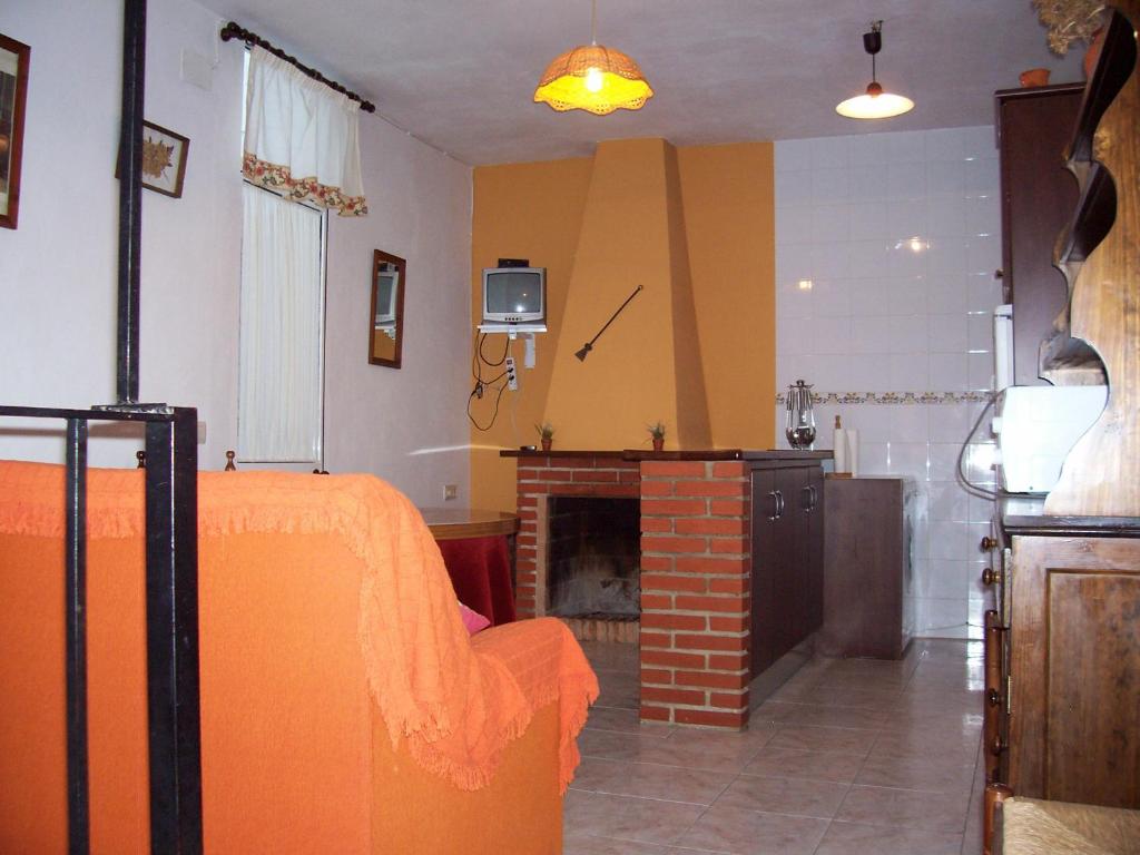 a bedroom with an orange bed and a fireplace at Casa Amigo in Castaño de Robledo