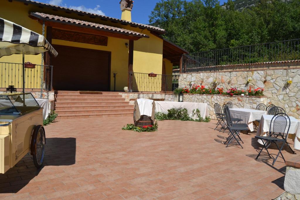 un patio con mesas y sillas y un edificio en Agriturismo Centuria en San Pio delle Camere