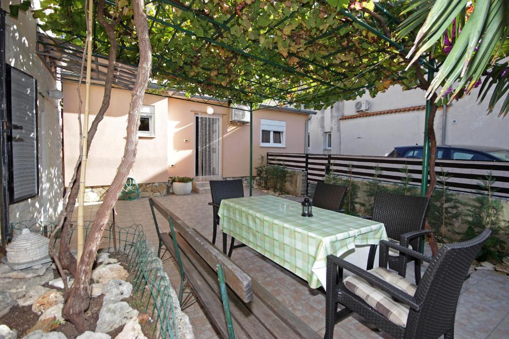 a patio with a table and chairs and a tree at Apartment Vesna in Premantura
