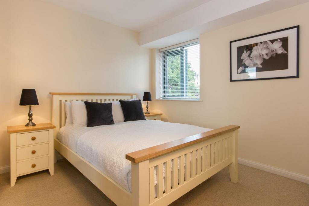 a bedroom with a white bed and a window at Citystay - Dove House in Cambridge