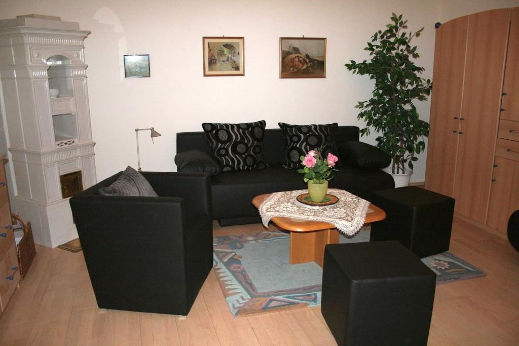 uma sala de estar com um sofá preto e uma mesa em 70m² großes Apartment mit Gartenzugang em Viena