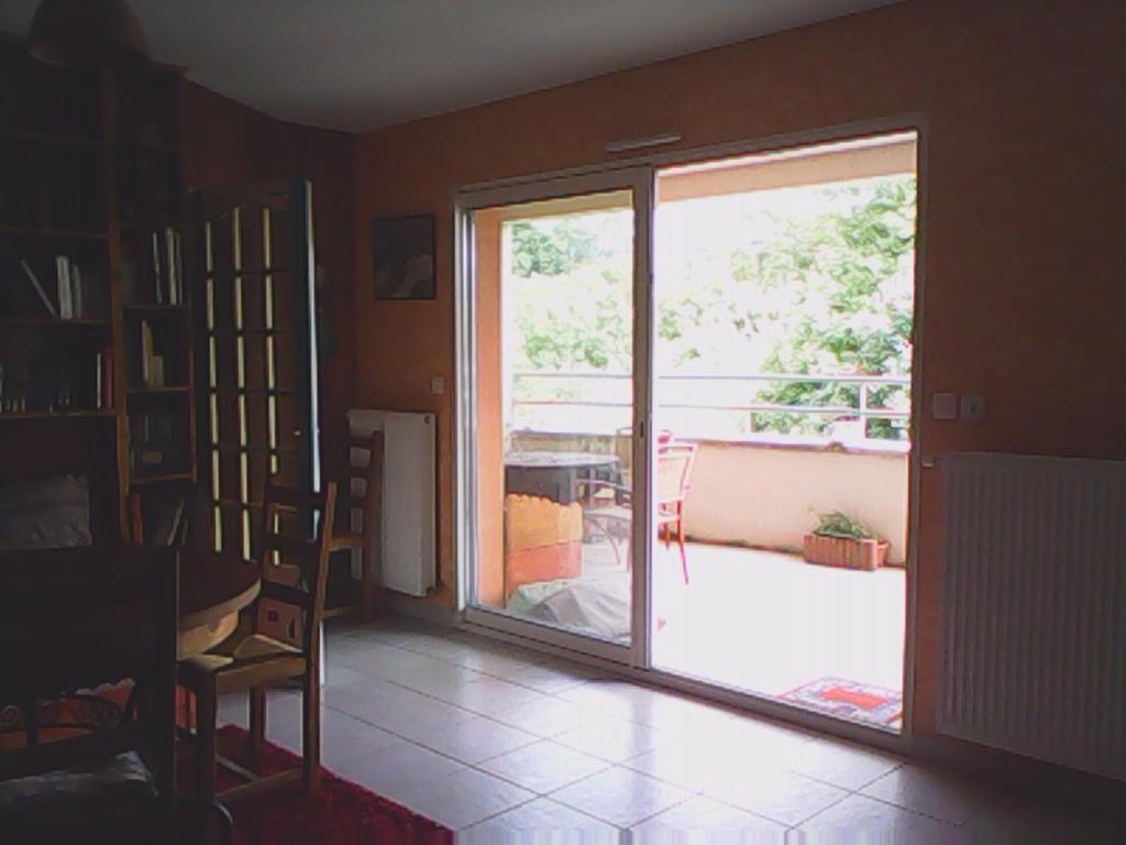 sala de estar con puerta corredera de cristal que da a un patio en rossignol, en Chatuzange-le-Goubet