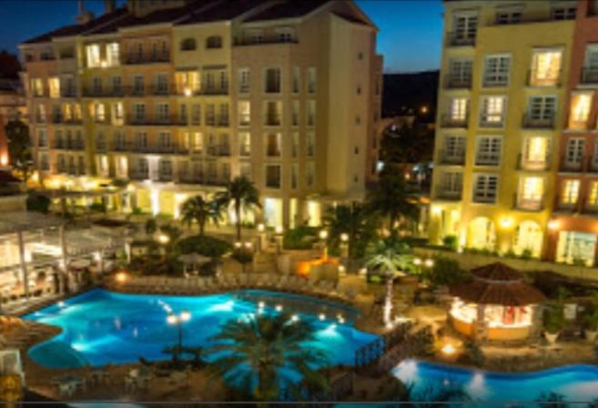 a view of a hotel with a swimming pool at night at Il Campanario Villaggio room in Florianópolis