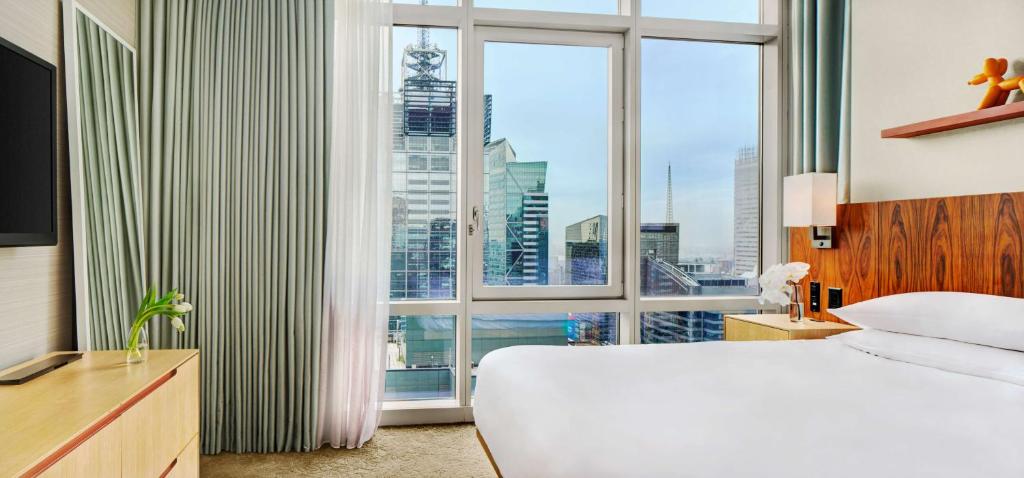 
a hotel room with a large window overlooking a city at Hyatt Centric Times Square New York in New York
