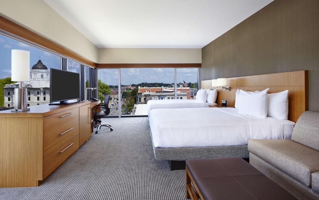 a hotel room with a bed and a flat screen tv at Hyatt Place Bloomington Indiana in Bloomington