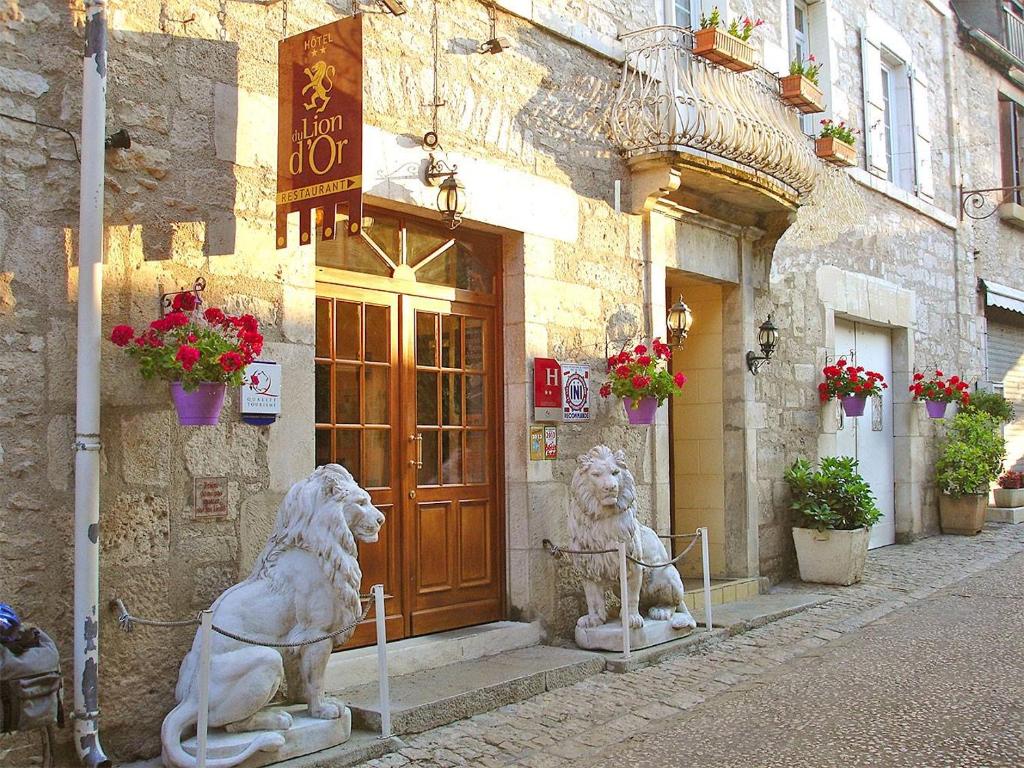 two statues of lions in front of a building at Hotel du Lion d'Or in Rocamadour