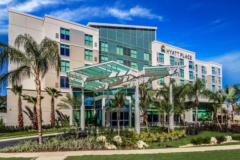a hotel with palm trees in front of a building at Hyatt Place Manati in Manati