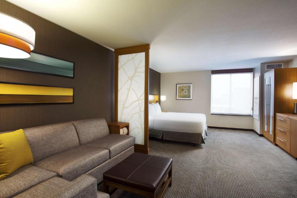 a living room filled with furniture and a window at Hyatt Place Chicago Midway Airport in Bedford Park