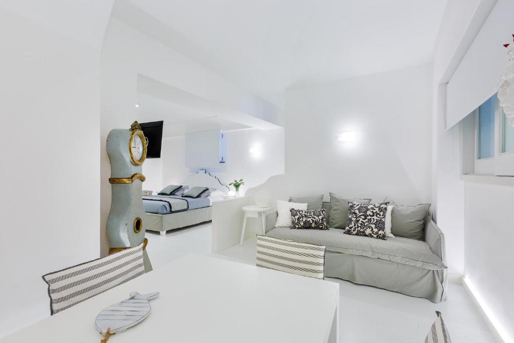 sala de estar blanca con sofá y cama en White Stylish Apartments, en Vico Equense