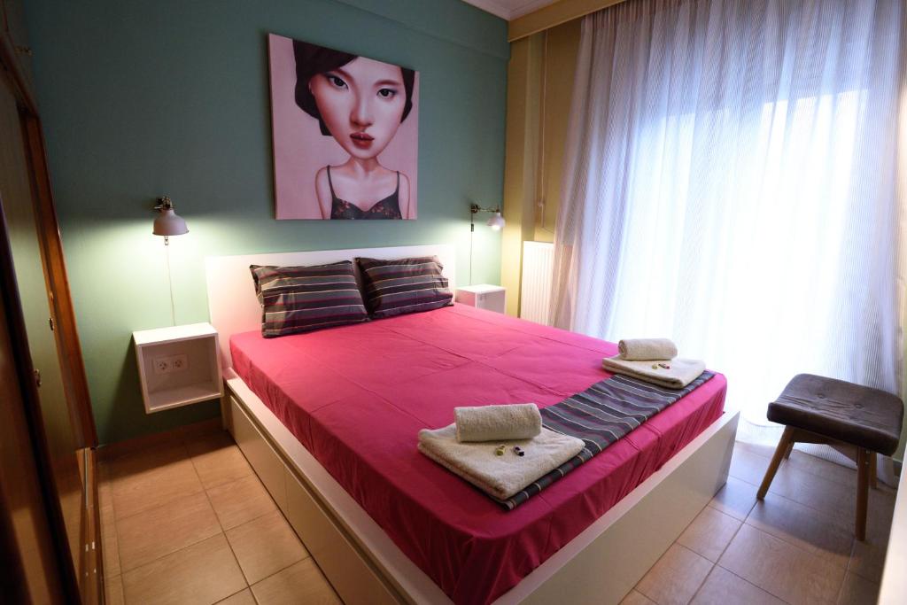 een slaapkamer met een roze bed en een schilderij aan de muur bij Anestis Home in Thessaloniki
