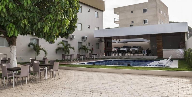 a patio with tables and chairs next to a building at Hotel Imperador in Salgueiro