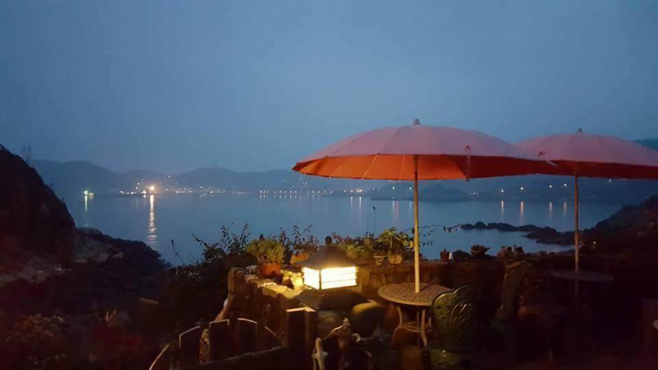 南竿鄉的住宿－夫人咖啡館民宿 ，两个桌子,在水面前,晚上有雨伞