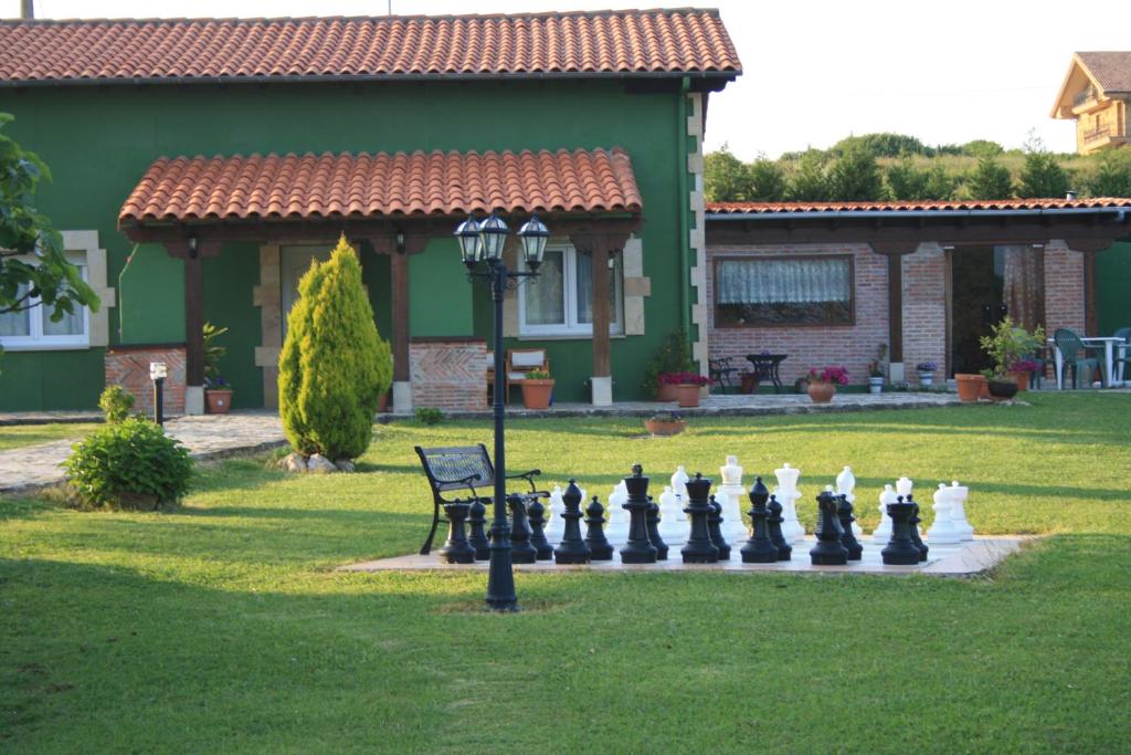 um tabuleiro de xadrez gigante em frente a uma casa em Alojamientos el Paramo em San Vicente de la Barquera