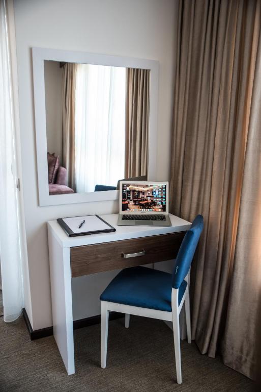 a desk with a laptop computer on it in front of a mirror at Boutique Hotel "Salina" in Ulcinj