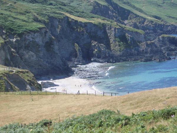 a group of people on a beach next to the ocean at Old Vicarage Mortehoe Near Woolacombe 2 x sleeps 4 and 1 x sleeps 10 cottages in Mortehoe