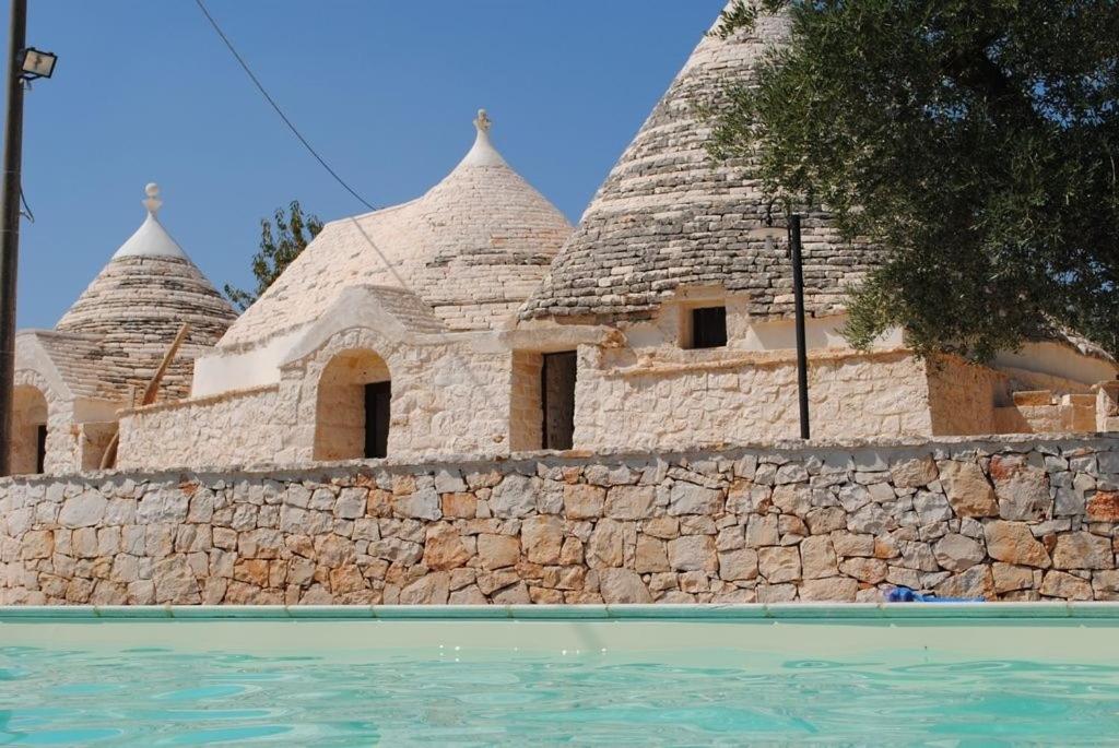 a building with domes on top of a stone wall at Trulli & Grotte Exclusive House in Castellana Grotte