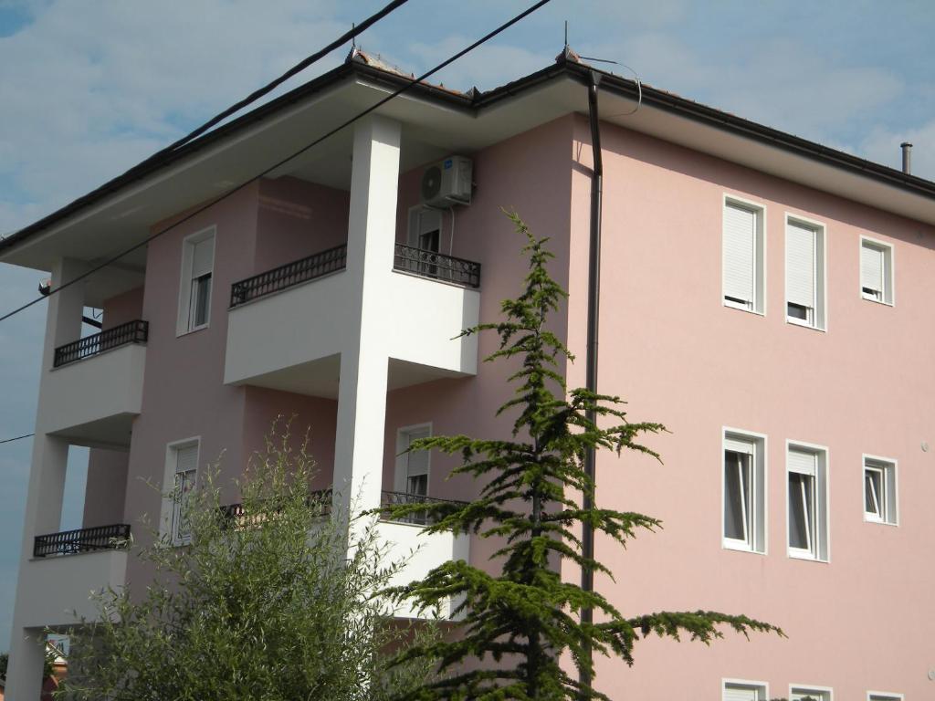 阿然德洛维克Apartment Srebrni oblak的一面有十字架的粉红色建筑