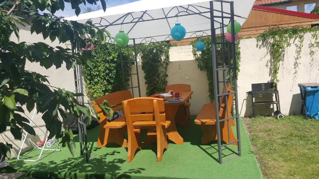 patio ze stołem i krzesłami na trawie w obiekcie Pokoje goscinne ''Muszelka'' w Świnoujściu