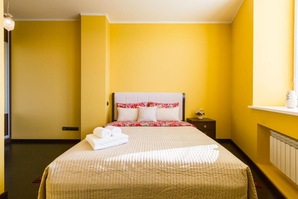 モスクワにあるCosy apartment on Profsoyuznayaのベッドルーム1室(黄色い壁、ベッド1台、タオル付)
