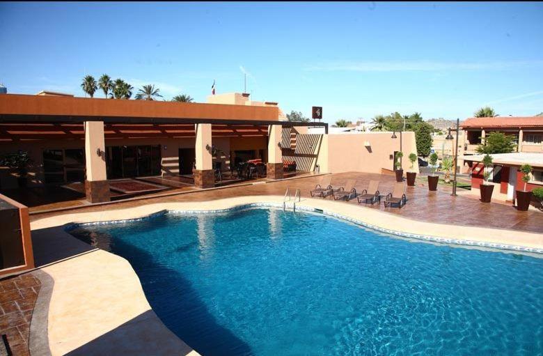 uma grande piscina em frente a um edifício em Hotel Gandara em Hermosillo