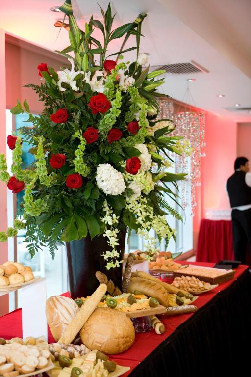 a large arrangement of red and white flowers on a table at Hotel Ciudad de David in David