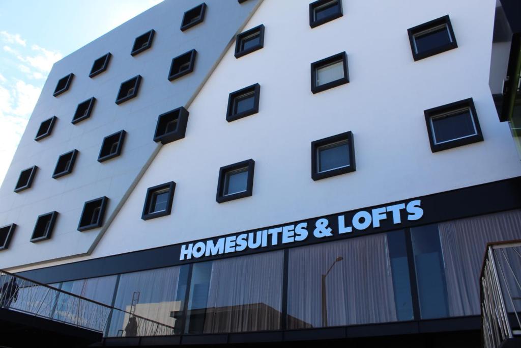 a building with a sign that reads homesteads and lotts at Homesuites Malecon in Culiacán