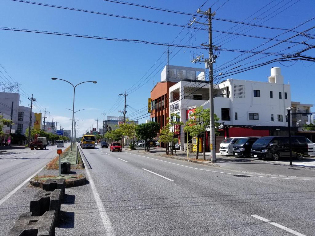 una calle vacía con coches aparcados a un lado de la carretera en Condominium Aoi Sanmyaku, en Okinawa City