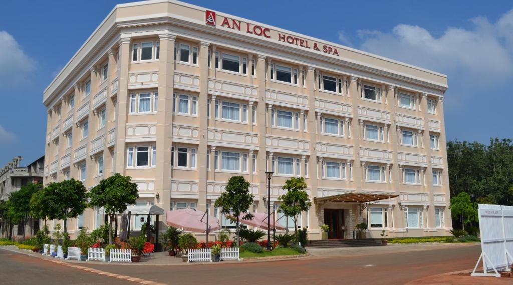un edificio de oficinas con un cartel de hotel de hielo en él en An Loc Hotel & Spa en Binh Long