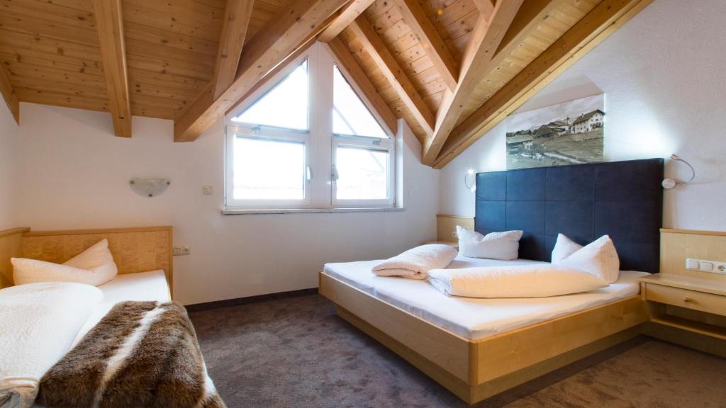 1 Schlafzimmer mit 2 Betten und einem großen Fenster in der Unterkunft Apart Haus Bernardes in Fiss