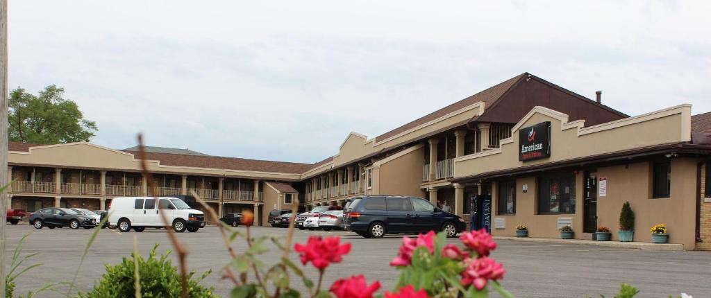 un edificio con coches estacionados en un estacionamiento en American Inn and Suites, en Countryside