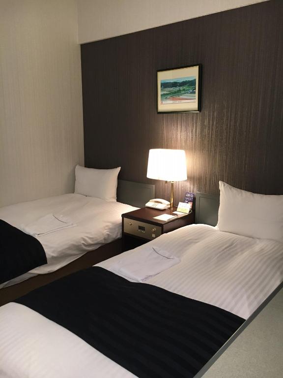 Postel nebo postele na pokoji v ubytování Tottori City Hotel