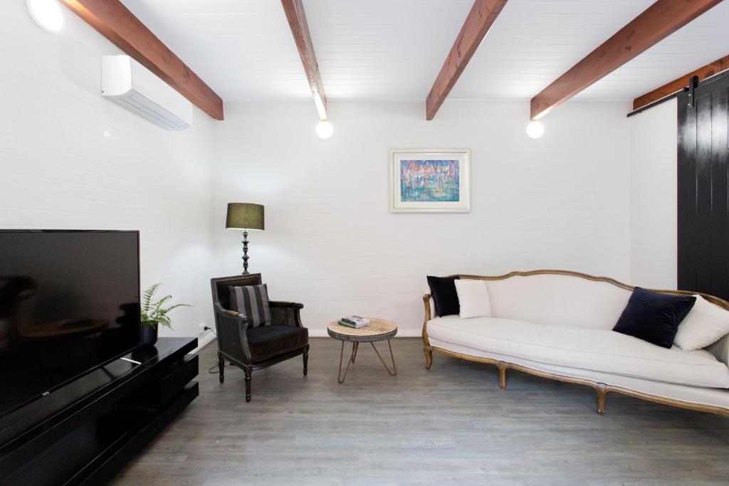 sala de estar con sofá blanco y TV en Stay Fresh - Fremantle CBD en Fremantle