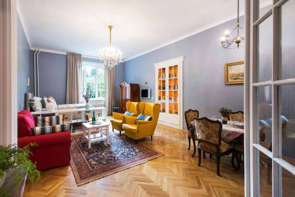 uma sala de estar com paredes azuis e cadeiras amarelas em Engel Apartman em Budapeste