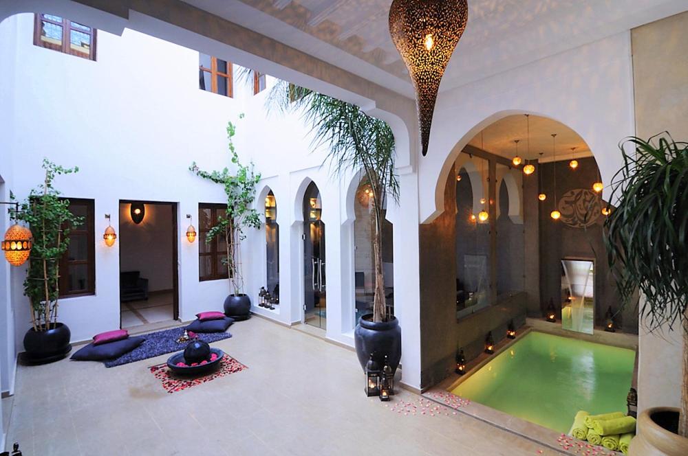 a large room with a swimming pool in a house at Riad Chayma Marrakech in Marrakech