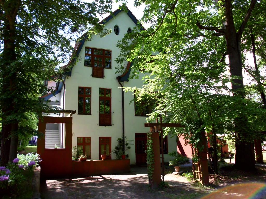 una casa blanca con árboles delante de ella en Haus Nixe en Loddin