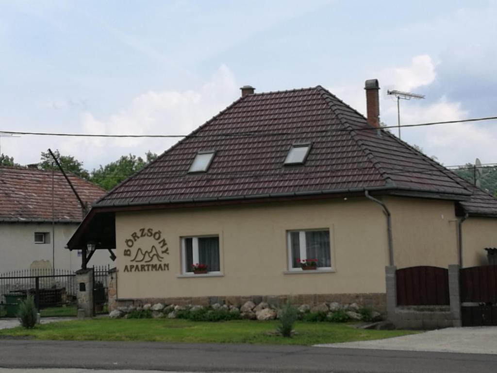 a house with a brown roof at Börzsöny Apartman in Kóspallag