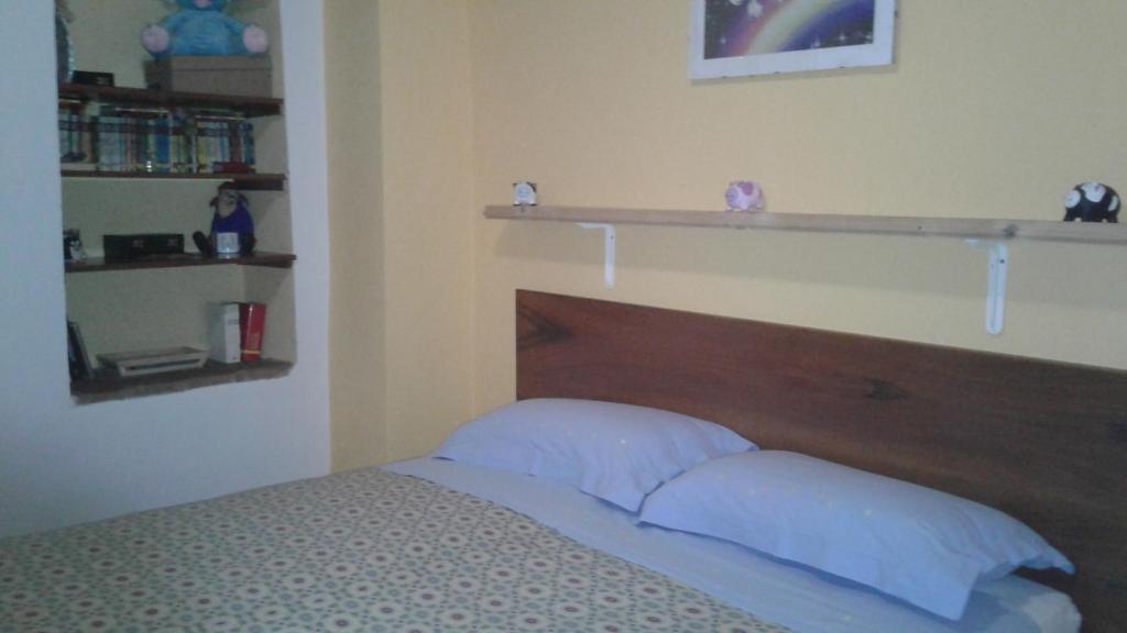 1 dormitorio con 1 cama con cabecero de madera y estanterías en Apartment Luzi, en Urbania