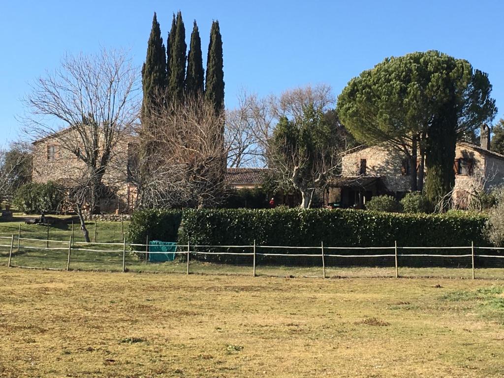 a house with a fence in front of a field at Podere Conte Ràcani in Amelia