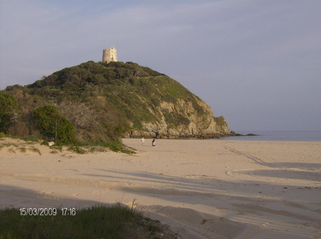 uma pequena ilha com um farol numa praia em Sa Colonia Chia em Chia