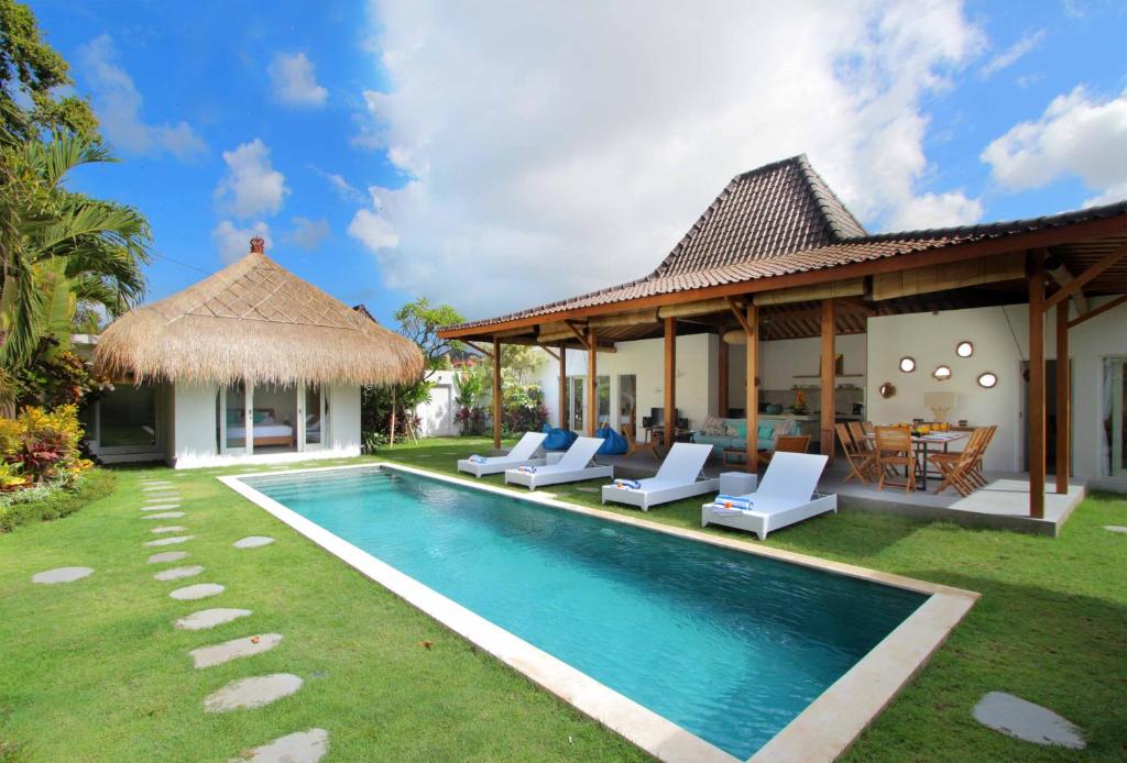 a villa with a swimming pool and a house at Villa Kaly by Optimum Bali Villas in Seminyak