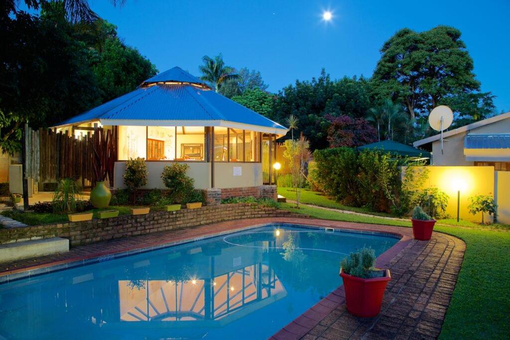 a house with a swimming pool with a gazebo at Christie's Inn in Tzaneen