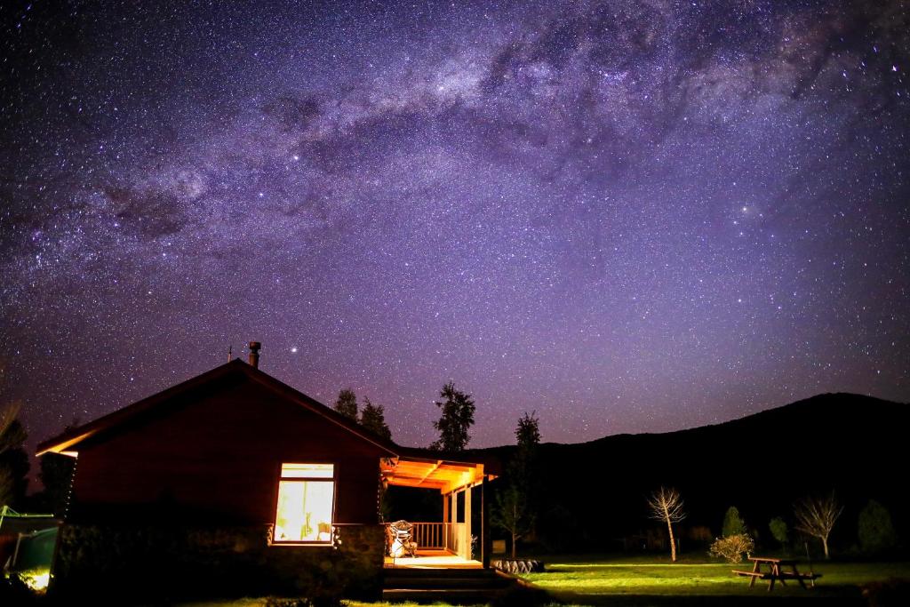 a cabin under a night sky with the milky way at Kepler Oaks Chalet in Te Anau