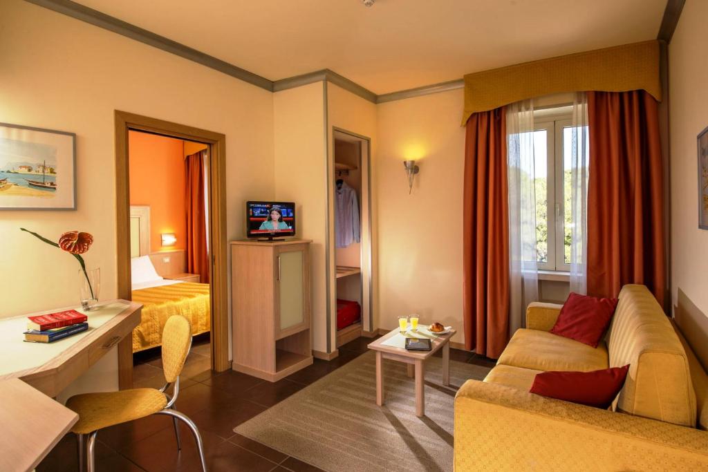 un soggiorno con divano e letto di Hotel Mediterraneo a Livorno